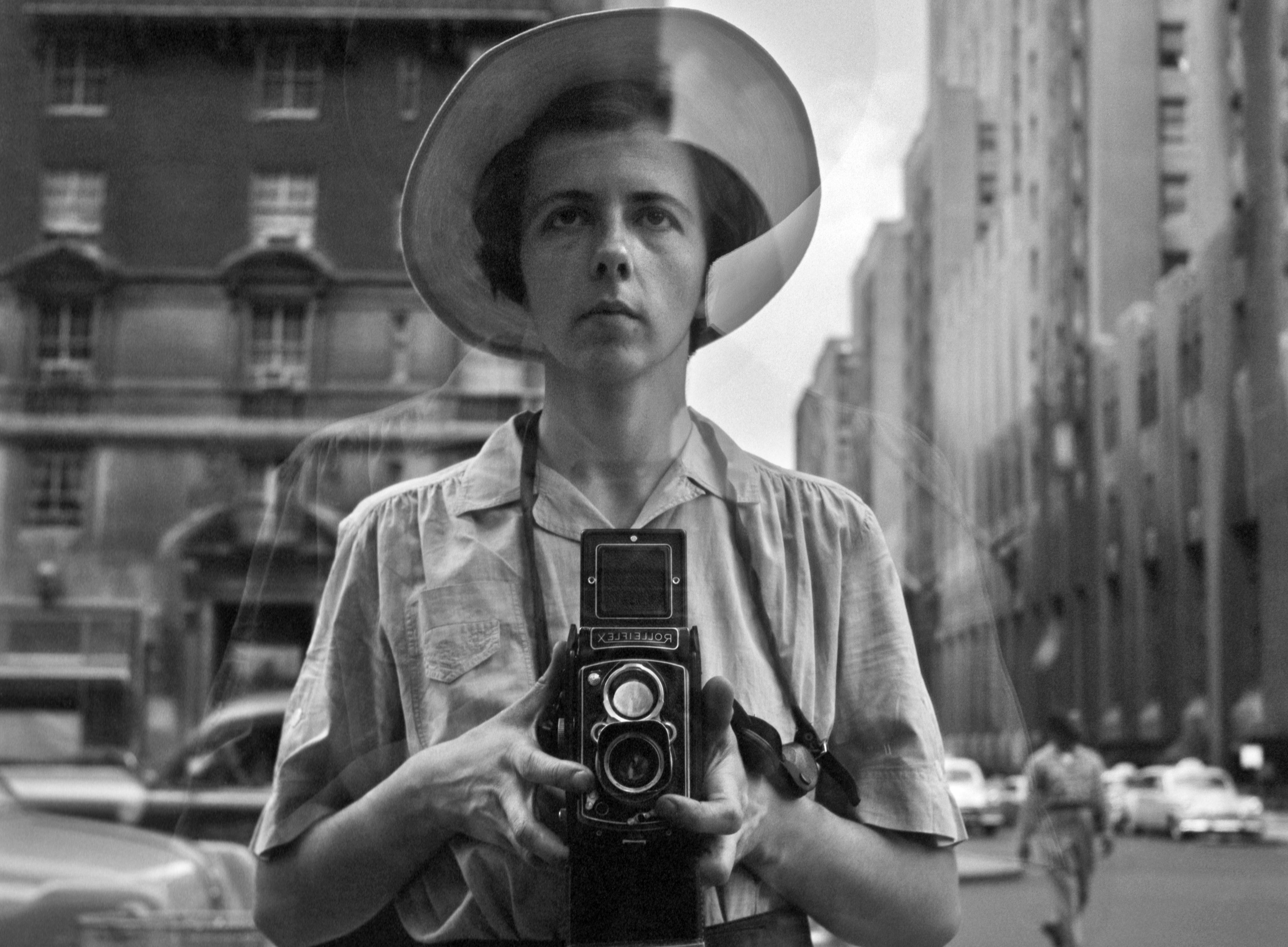 A self portrait of Vivian Maier in a store window.