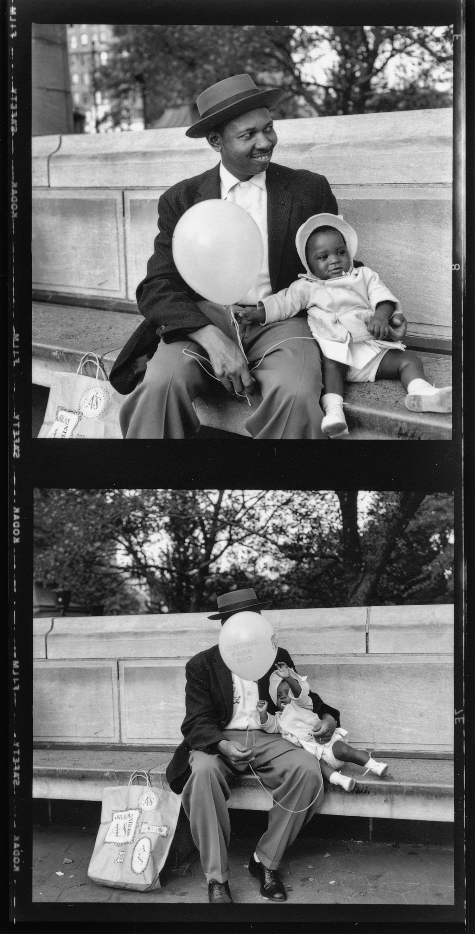 A man holds a baby and a balloon.