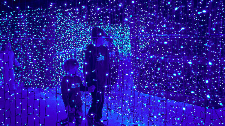 Two kids walk through lights