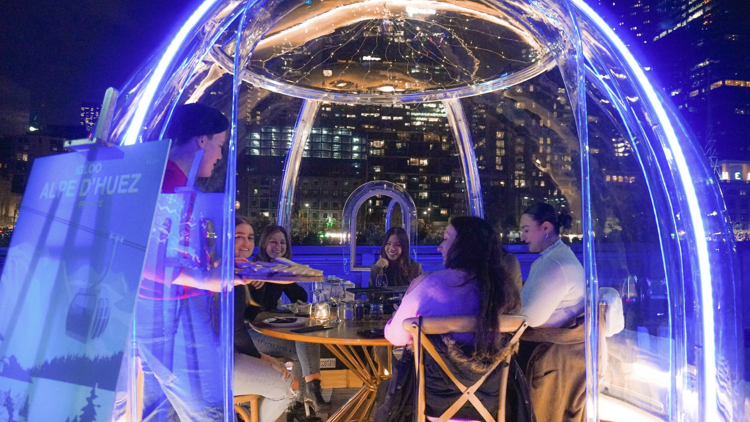 A group of people inside a neon lit igloo