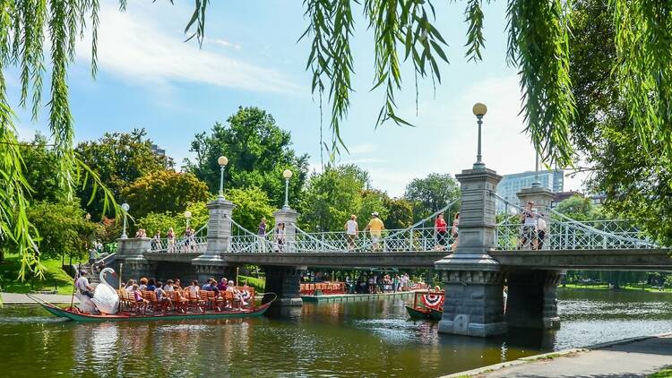 Swan Boat with tourists and foot bridge at the Boston Public Garden on August 20, 2012. 