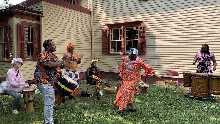 people dancing outside a historical house