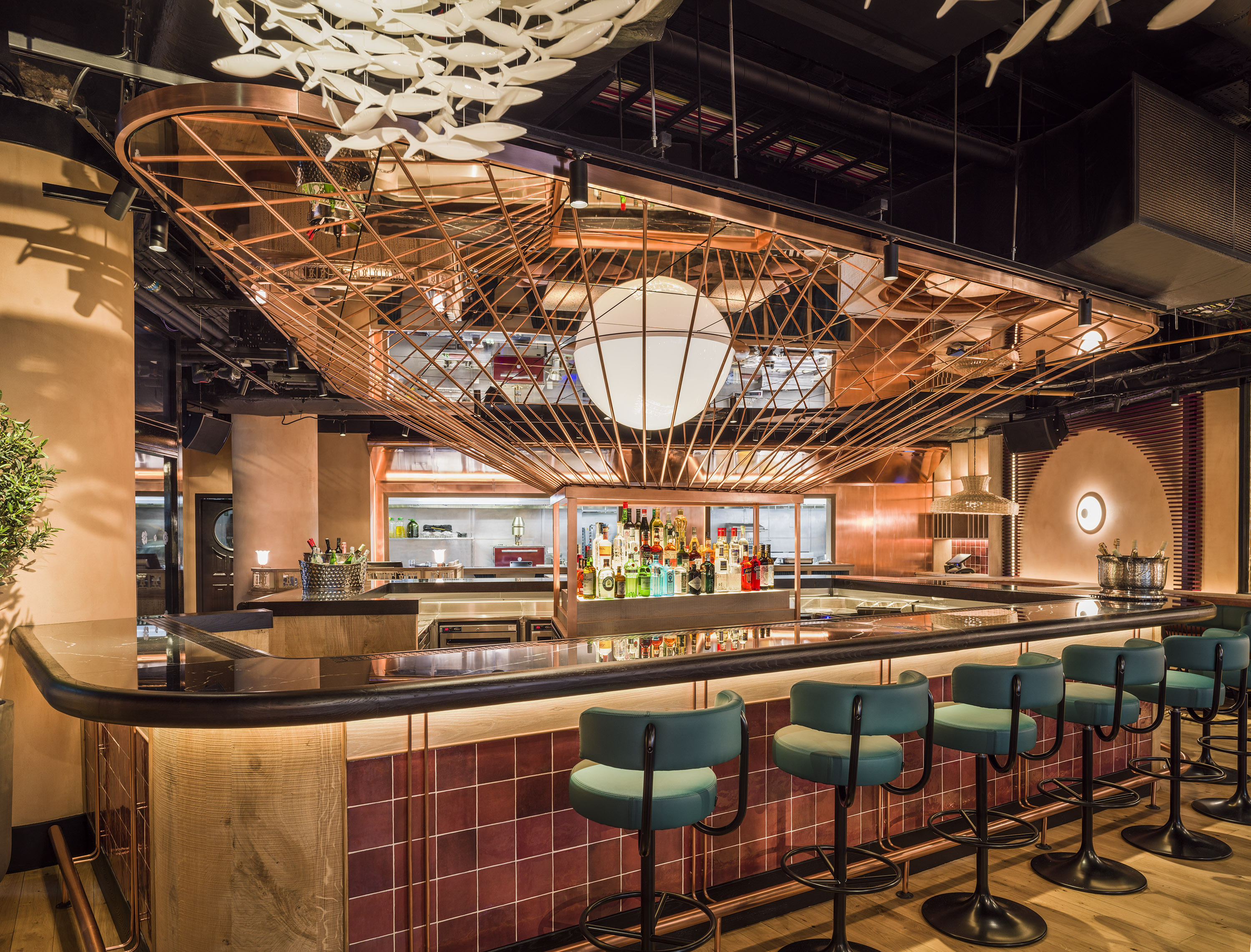 Lit up bar area with black countertop and green stools