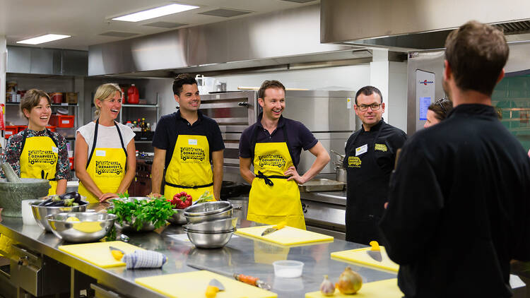 Team in yellow aprons taking cooking class