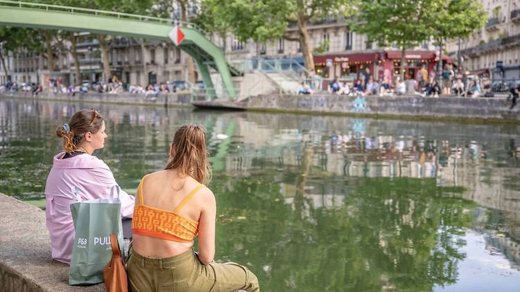 Young people sitting along the Seine in Paris