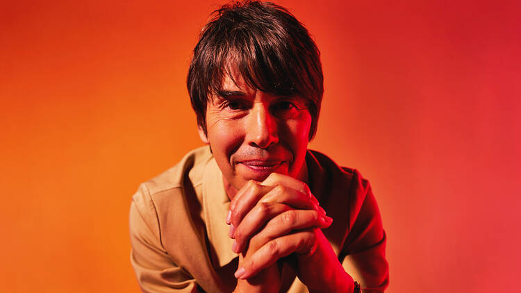 Brian Cox with a red backdrop