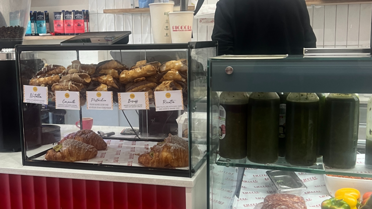 Staff member behind the counter at Piccolo Panini Bar.