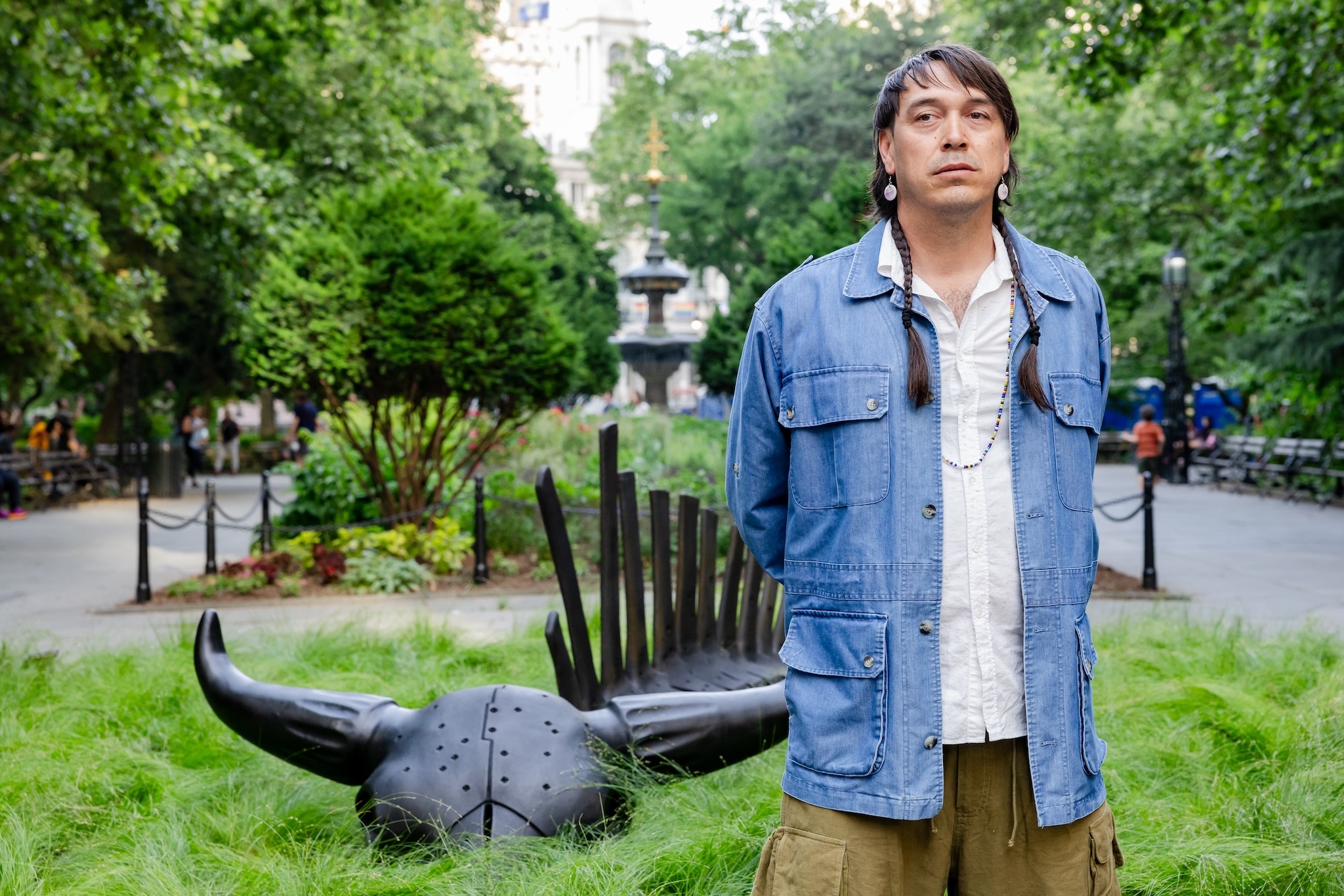 The artist stands next to the bison sculpture.