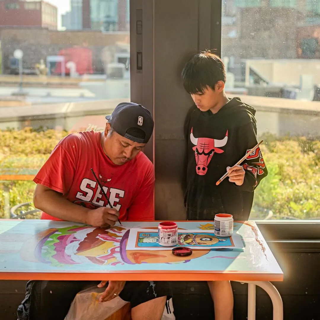 Two people painting a table