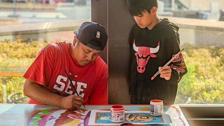 two people painting a table