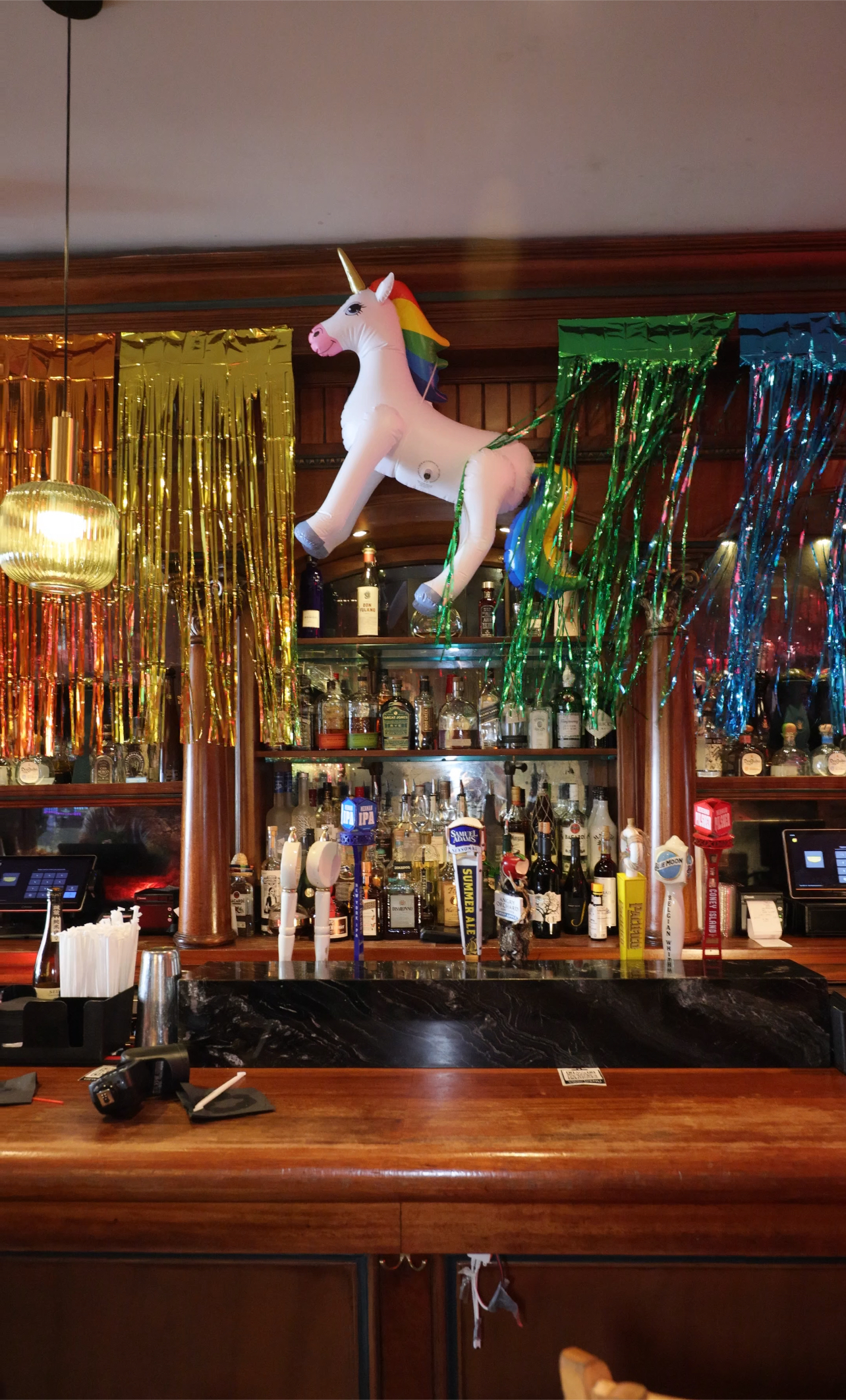 a bar with an inflatable unicorn and rainbow streamers