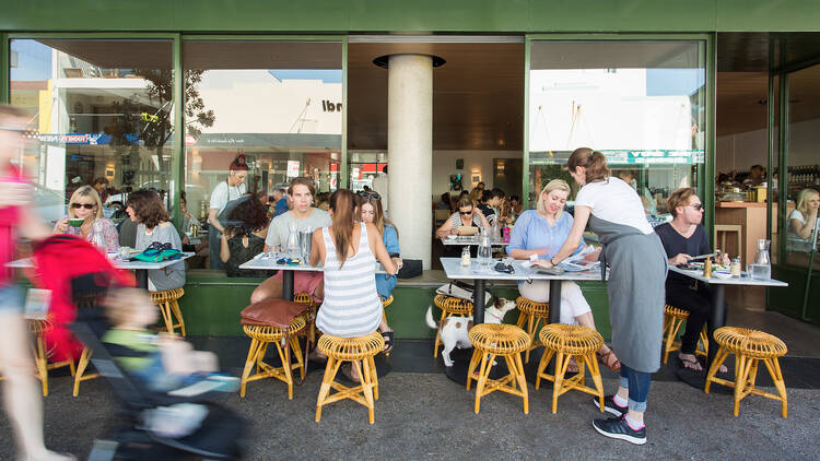 People dining on footpath outside cafe