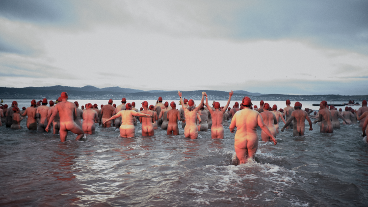 People running into water nude with red caps on