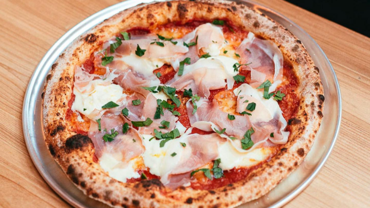 Ham and parmesan pizza on table