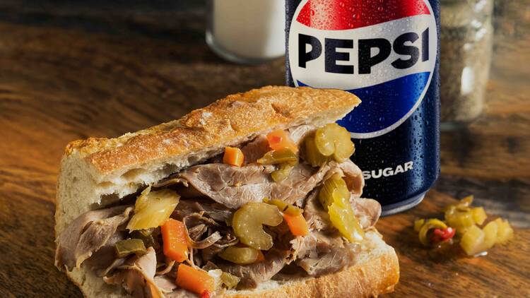 An italian beef sandwich and a pepsi