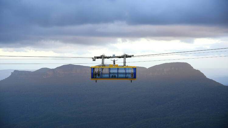 Man atop the Scenic Skyway cabin as part of the Beyond Skyway experience at Scenic World, Katoomba.