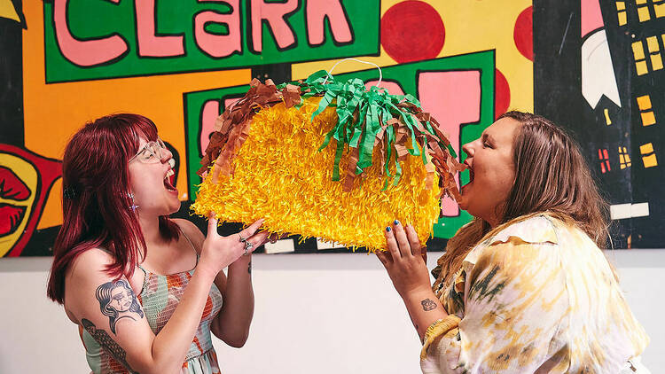 Two people pretending to eat a taco pinata