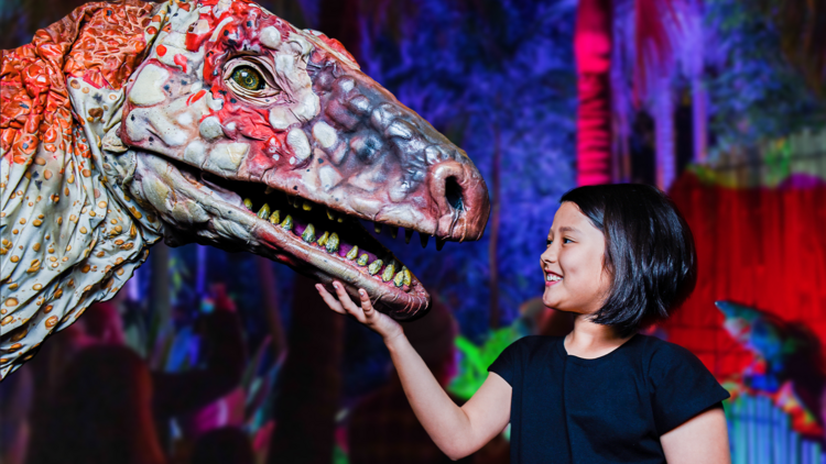 A child touches a replica dinosaur