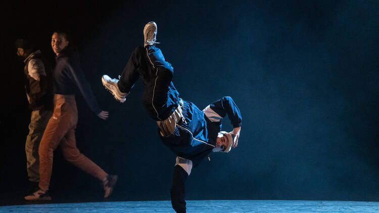 A hip-hop dancer doing a one-handed handstand 