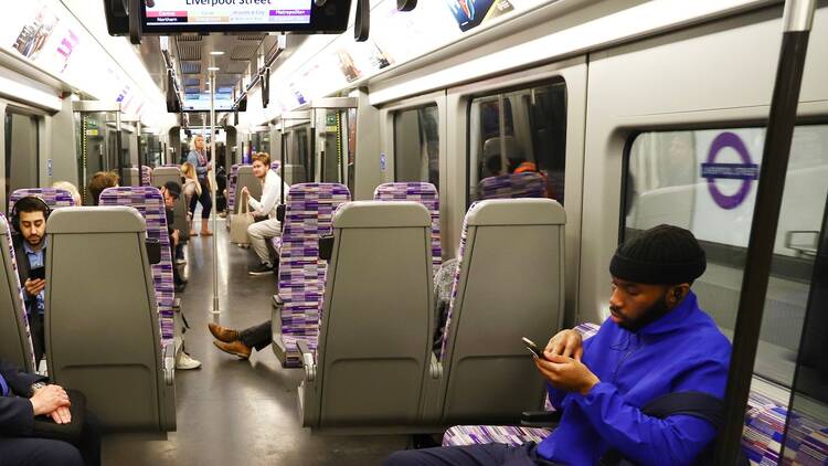 customer travelling on tube using mobile phone