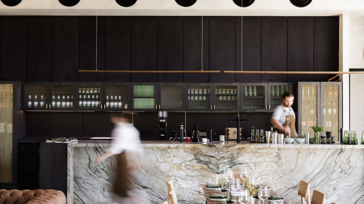 Marble bar with bartender setting up cocktail station