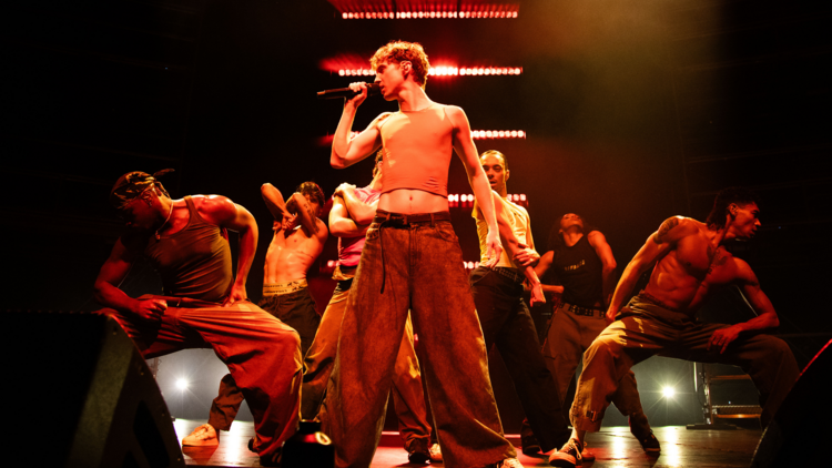 Troye on stage surrounded by dancers