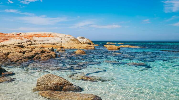 Brown rock formation on blue sea under blue sky during daytime