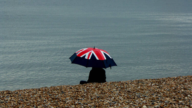 Union jack umbrella on a beach in the UK, bad weather