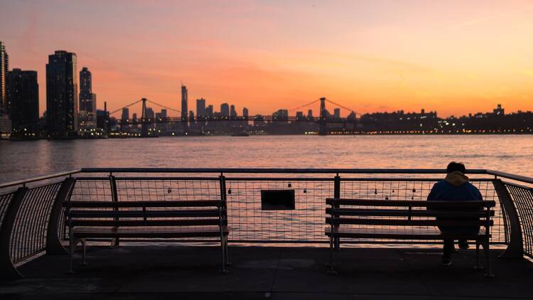 Silhouette of a Man on a Bench at WNYC Transmitter Park in Green Point Brooklyn Watching the Sunset on the East River