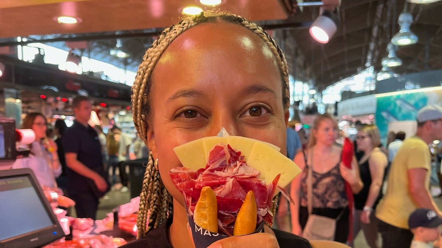 Picture of Morgan Carter holding a paper cone filled with cheese, charceuterie, and breadsticks