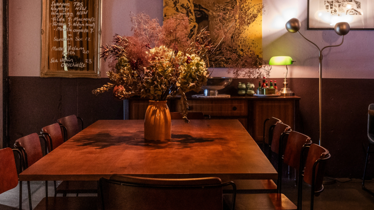Table, chairs and flowers in a vase in an intimate wine bar.