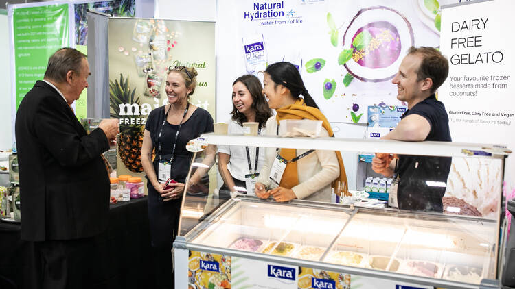 People at an ice cream stand talking and smiling at Fine Food Australia.