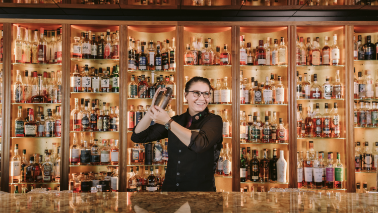 Inside of bar with bartender shaking cocktail