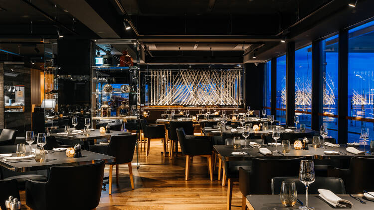 Interior of restaurant with black chairs and tables