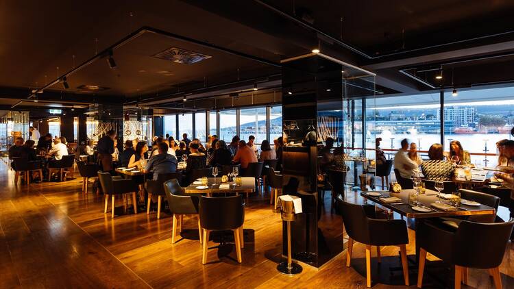 Restaurant interior with tables, chairs and big open windows 