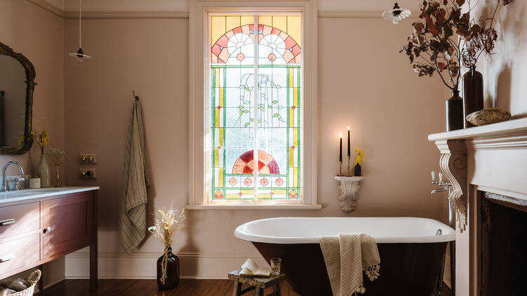 Old-school bathroom with bath tub and stained glass window