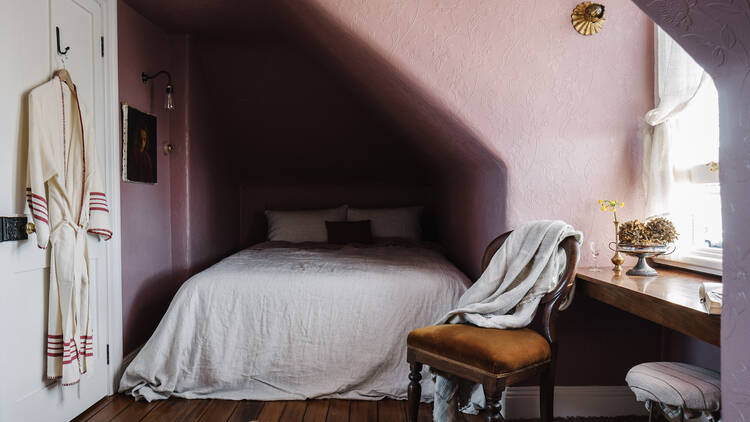 Attic room with double bed and pink walls