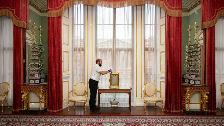 Image of man cleaning ornament in the East Wing