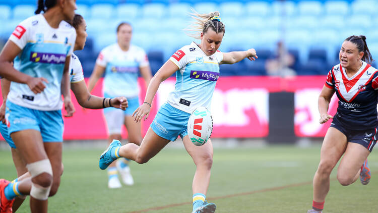 Female rugby league players on field.