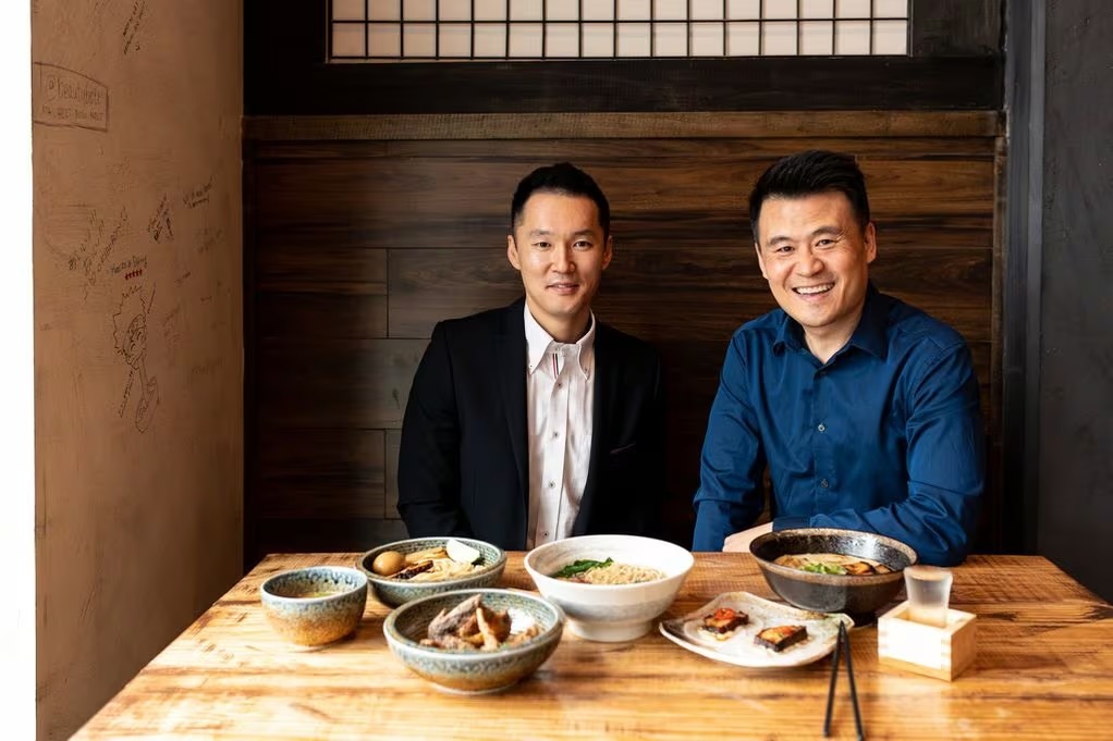 Photo of Naoki Kyobashi and Justin Lim sitting at a table