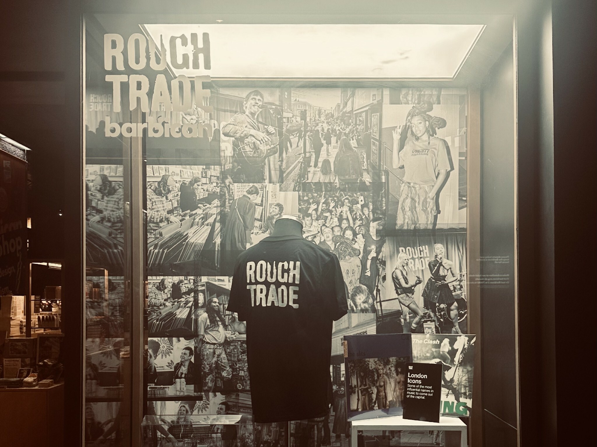 A Rough Trade and Barbican Centre display featuring a Rough Trade t-shirt and posters