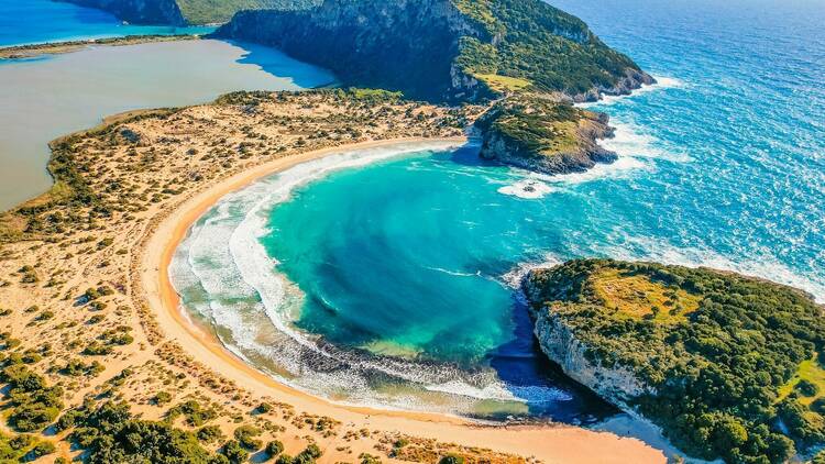 Aerial view of voidokilia beach, lagoon with beaches in mediterranean, Ionian Sea, Pylos town , Greece. Navarino Castle on hill.