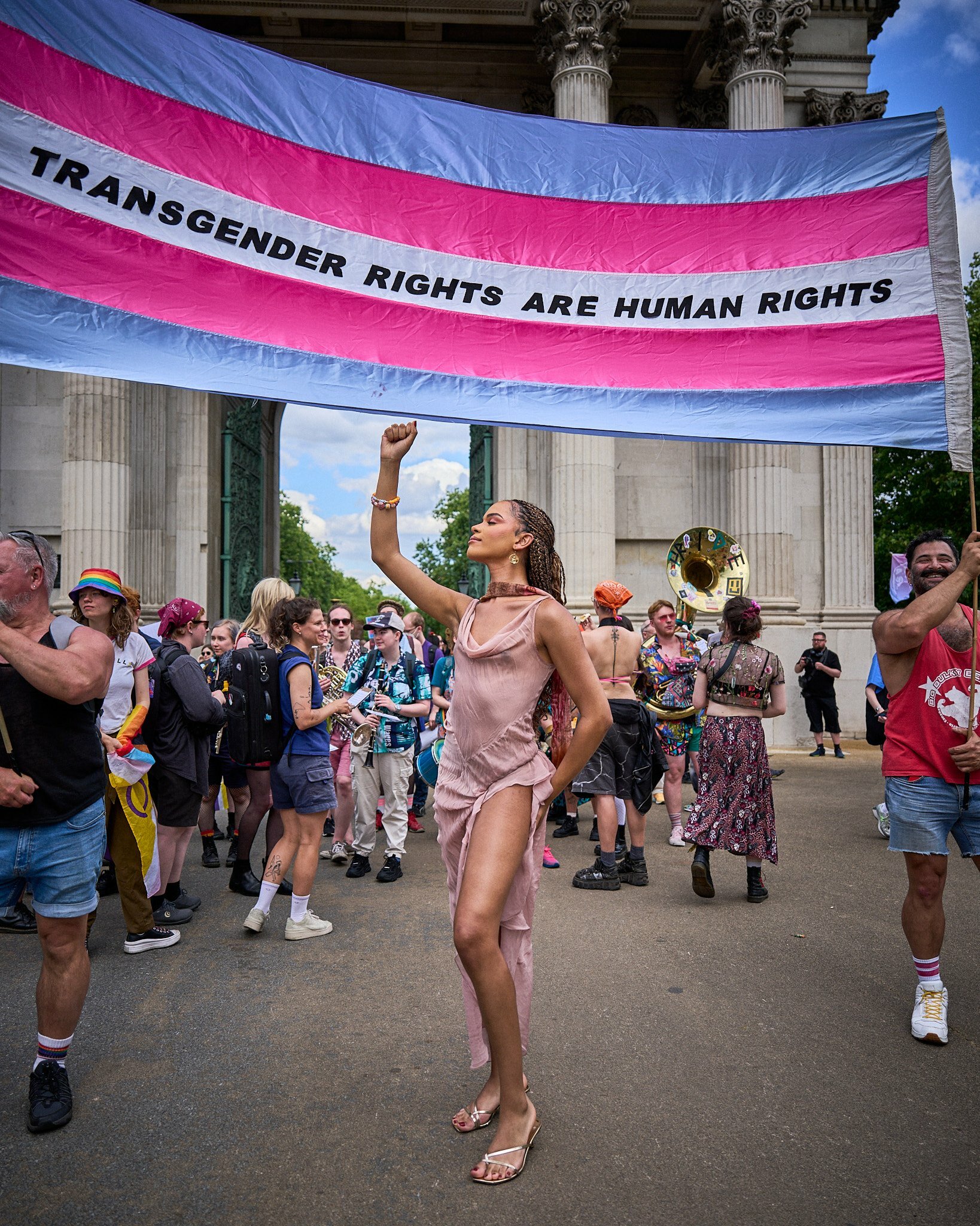 Yasmin Finney standing under a banner at trans pride 