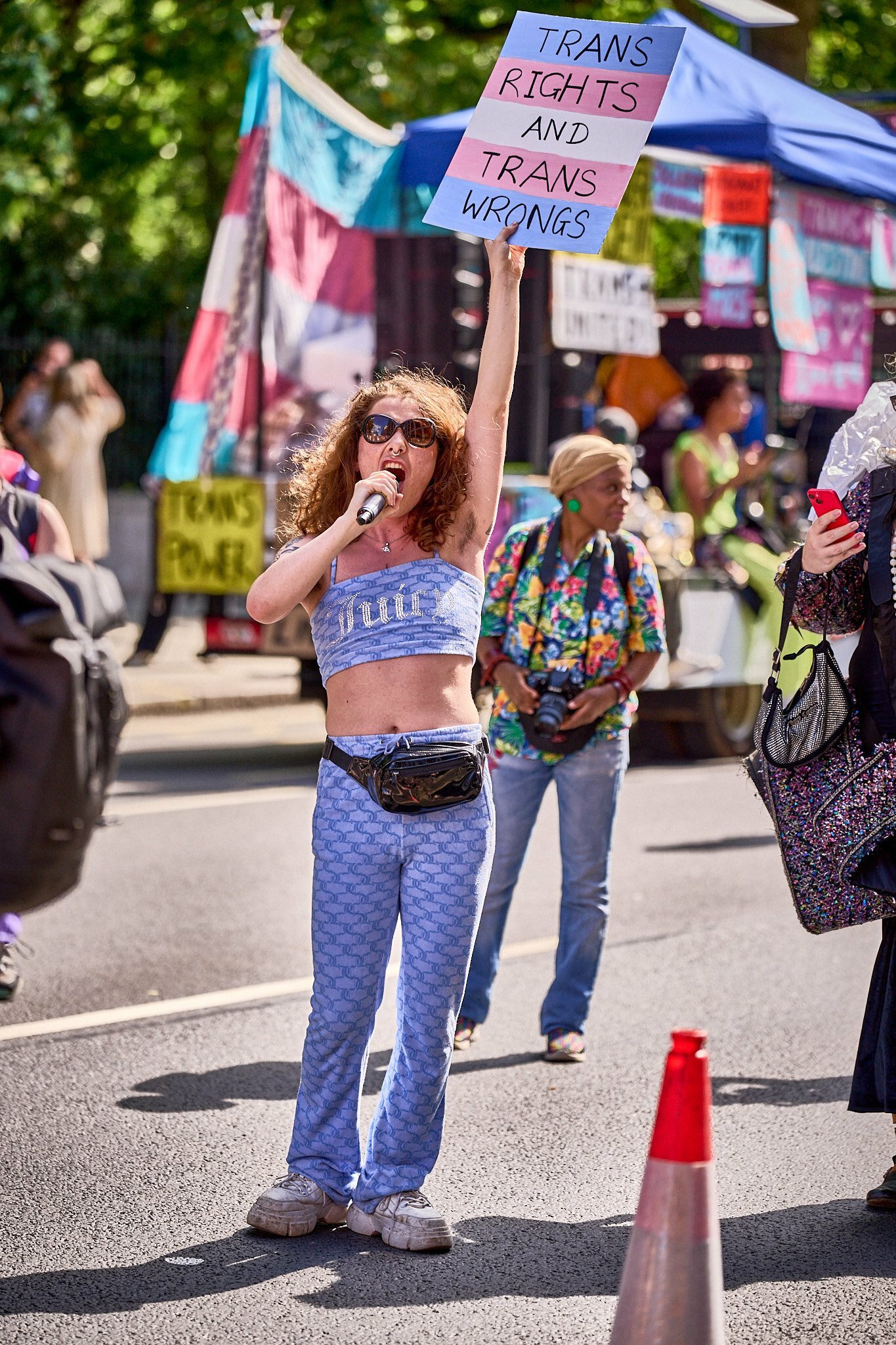 A woman holding a 'trans rights and trans wrongs' placard  