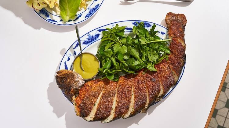 A deboned rainbow trout stuffed with fish cake mousse, shrimp, green mustard condiment and lettuces