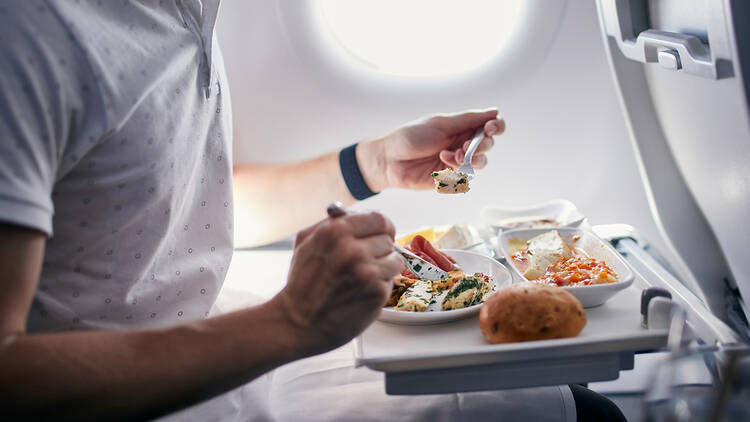 Passenger eating in-flight meal on an aeroplane