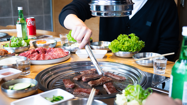 People cooking meat on a Korean barbecue 