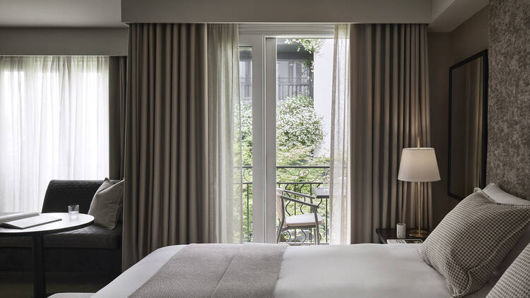 A hotel bed next to a window. 