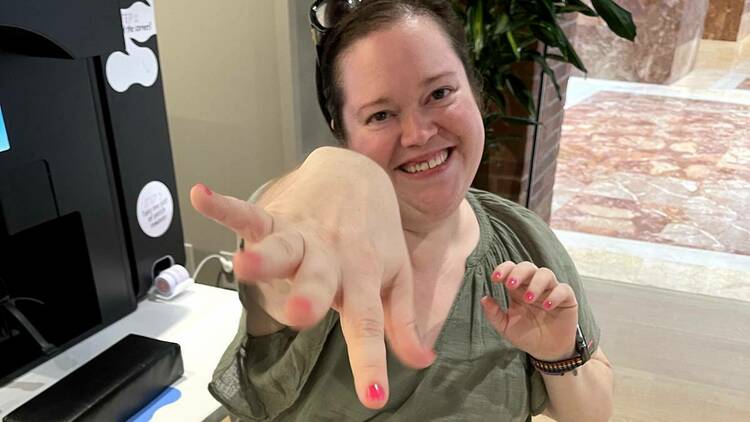 Writer Tara Bellucci shows of her bright pink nails painted by a robot in Boston.