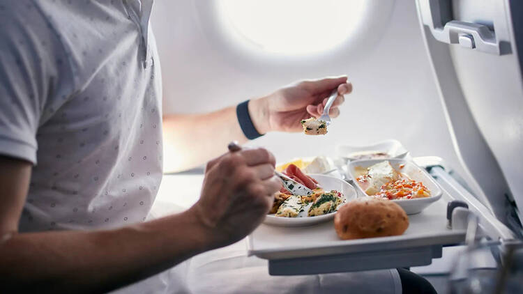 Passenger eating in-flight meal on an aeroplane